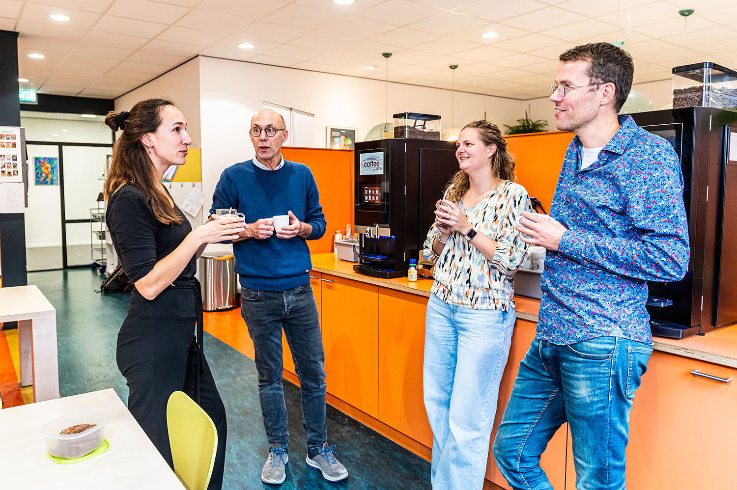 Een groep collega's in de personeelskamer van het Kalsbeek College locatie Schilderspark